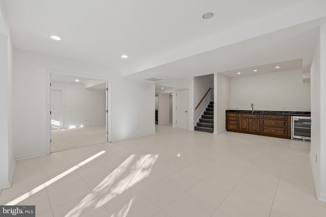 interior space with wine cooler, light tile patterned floors, and wet bar