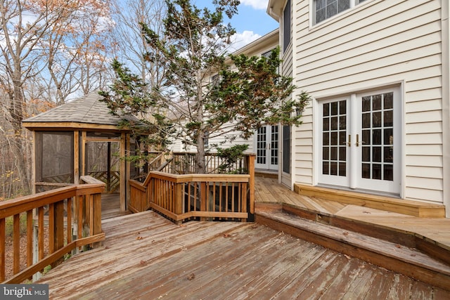 wooden terrace with a gazebo, a sunroom, and french doors