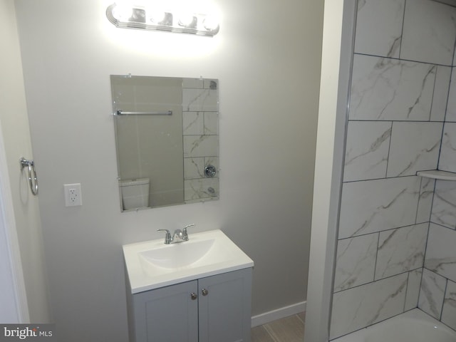 bathroom featuring tiled shower / bath and vanity