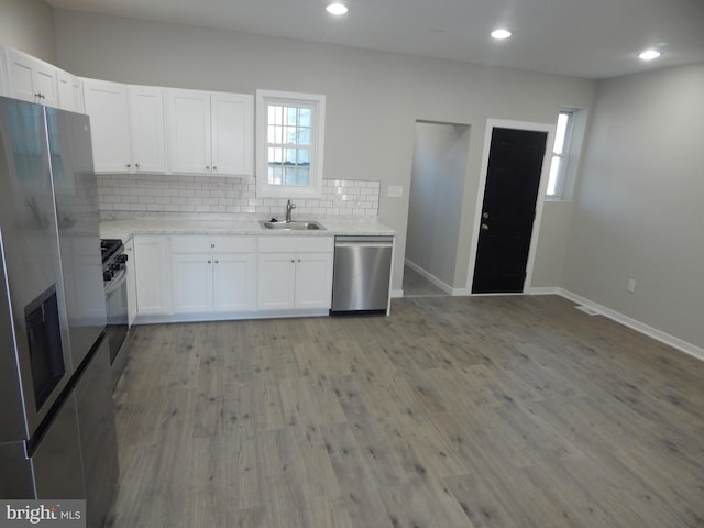 kitchen with light wood-type flooring, white cabinetry, sink, and stainless steel appliances