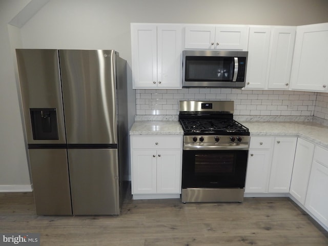 kitchen featuring white cabinets, hardwood / wood-style flooring, and appliances with stainless steel finishes