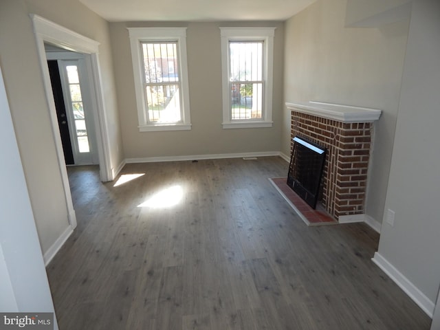 unfurnished living room featuring a fireplace and dark wood-type flooring