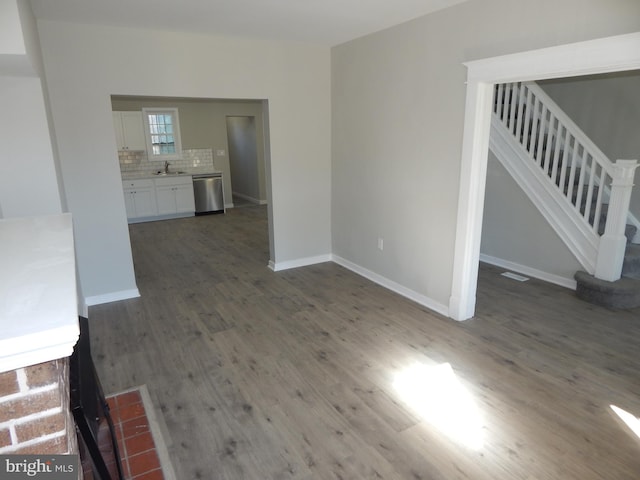 unfurnished living room with dark wood-type flooring and sink