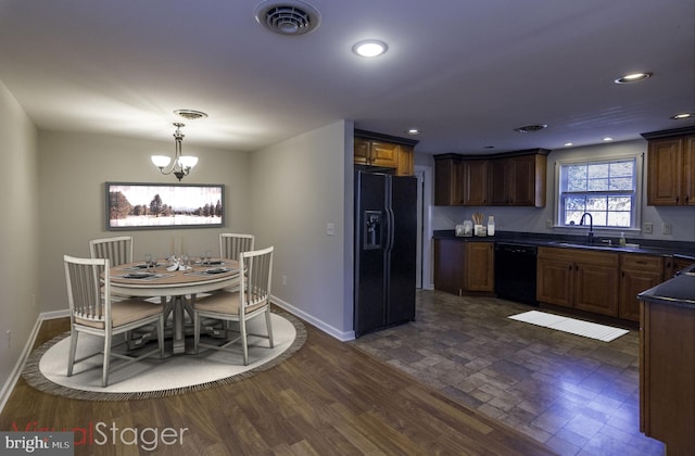 kitchen with visible vents, a sink, black appliances, and dark countertops