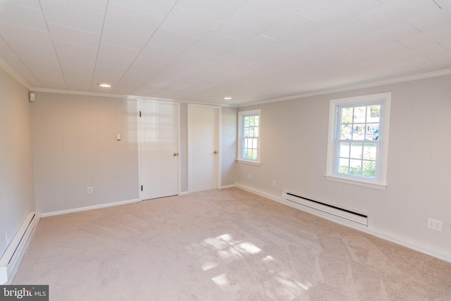 unfurnished room featuring crown molding, a baseboard heating unit, and light colored carpet