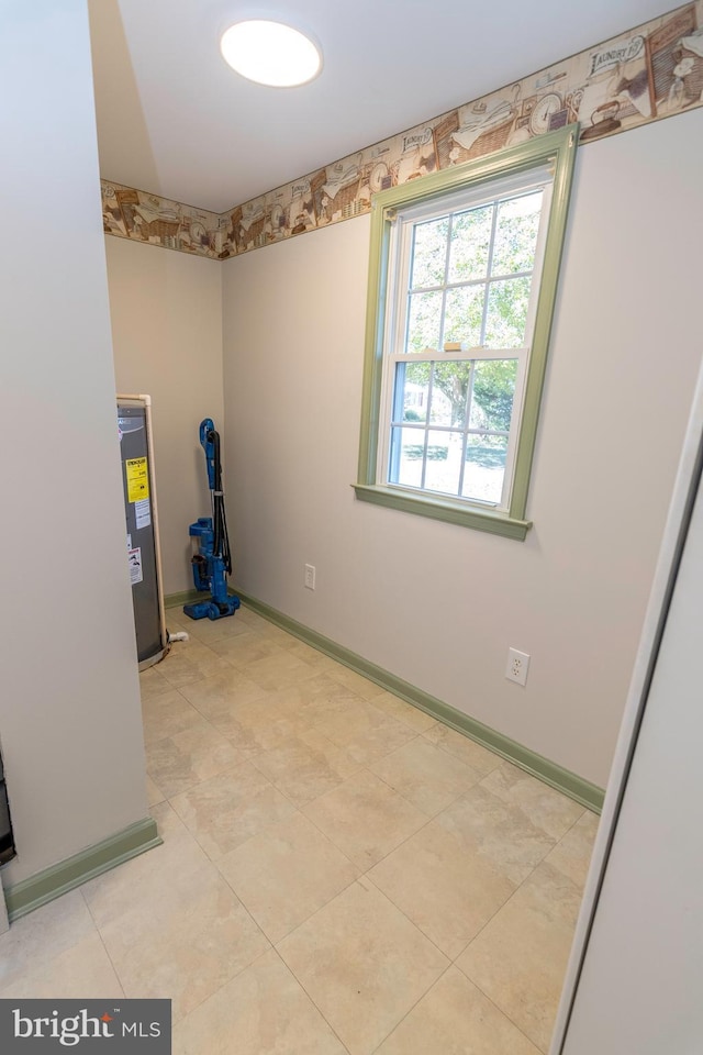 spare room with electric water heater and baseboards