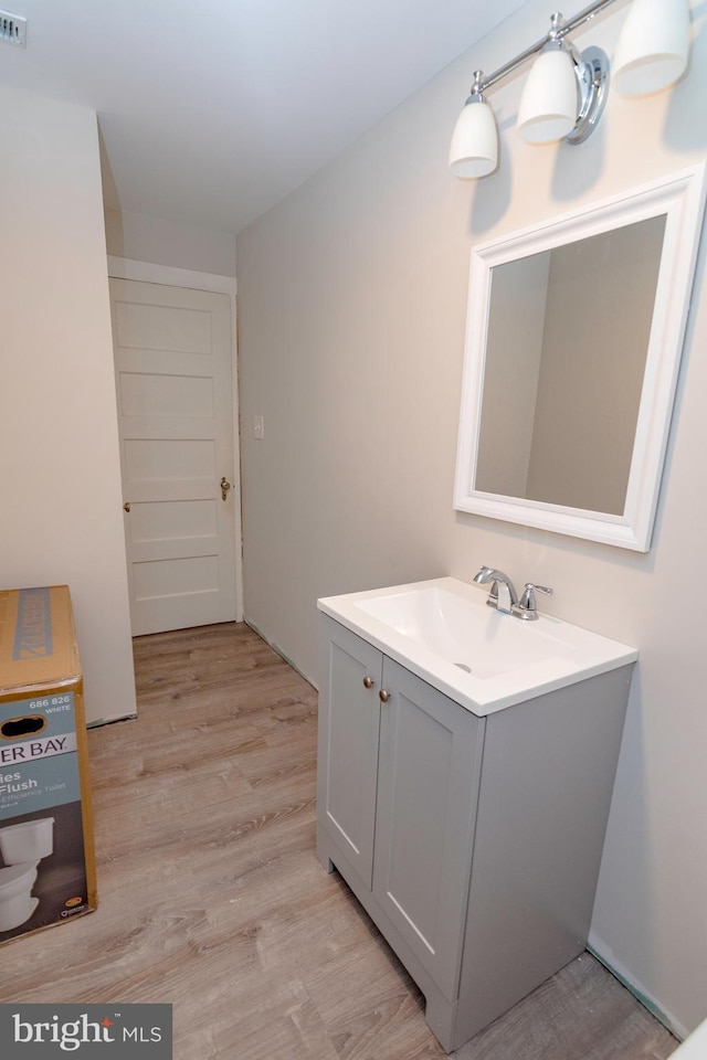 bathroom featuring visible vents, vanity, and wood finished floors