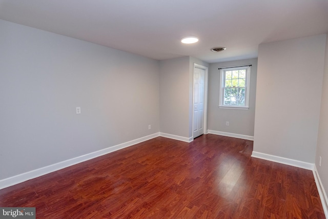 spare room with visible vents, baseboards, and wood finished floors