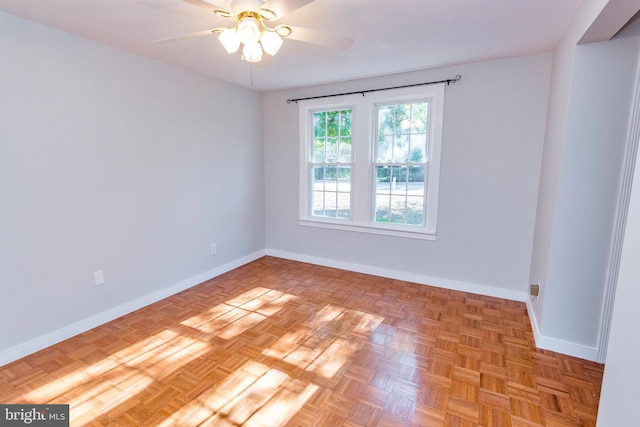 spare room featuring baseboards and a ceiling fan