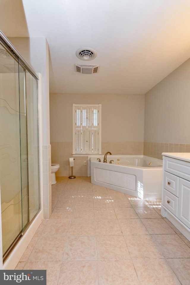 bathroom featuring a shower stall, tile patterned flooring, visible vents, and tile walls