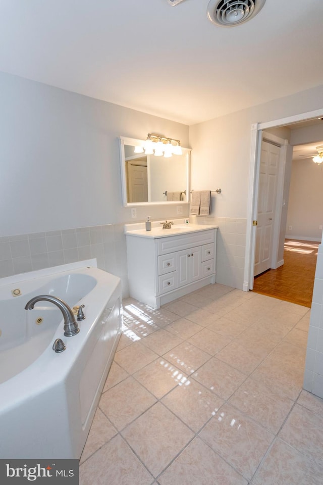 full bath with a whirlpool tub, tile patterned flooring, vanity, and visible vents