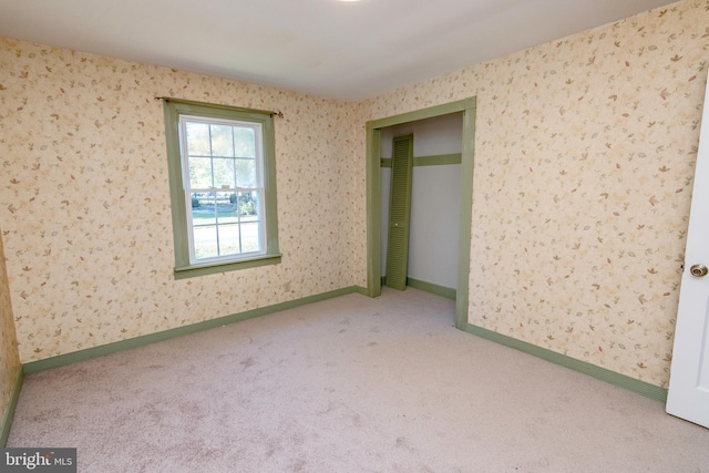 unfurnished room featuring baseboards and carpet