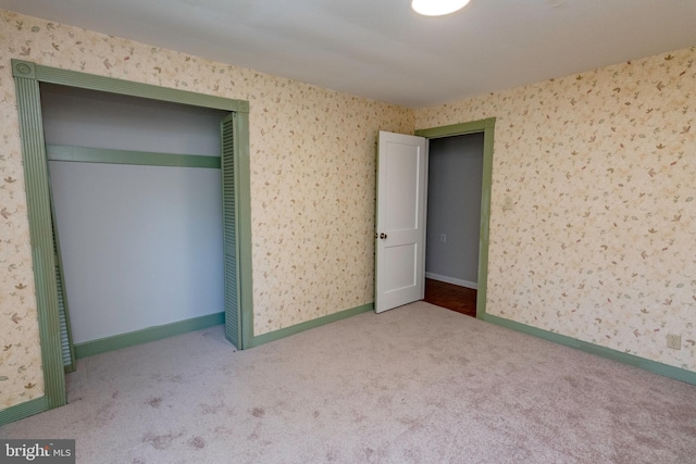 unfurnished bedroom featuring carpet flooring, a closet, and wallpapered walls