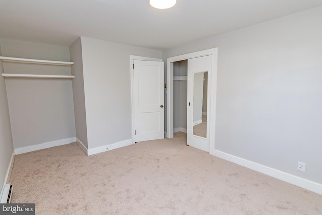 unfurnished bedroom with baseboard heating and light colored carpet