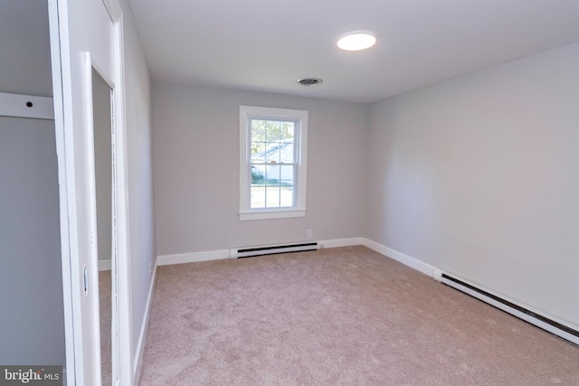 carpeted spare room with baseboard heating, baseboards, and visible vents