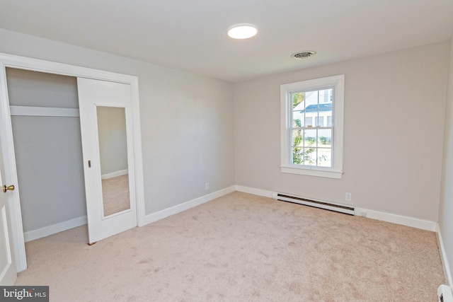 unfurnished bedroom featuring light carpet, a closet, and a baseboard radiator