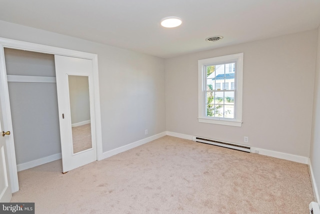 unfurnished bedroom featuring visible vents, a baseboard heating unit, baseboard heating, and carpet floors