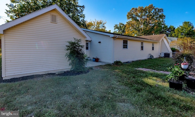 view of side of property featuring a yard and central air condition unit