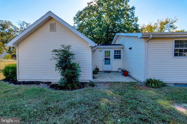 back of property featuring a patio area and a lawn