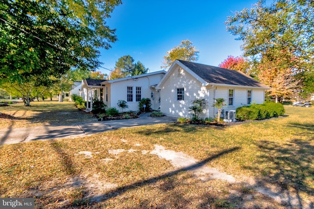 view of side of home featuring a yard and central AC unit