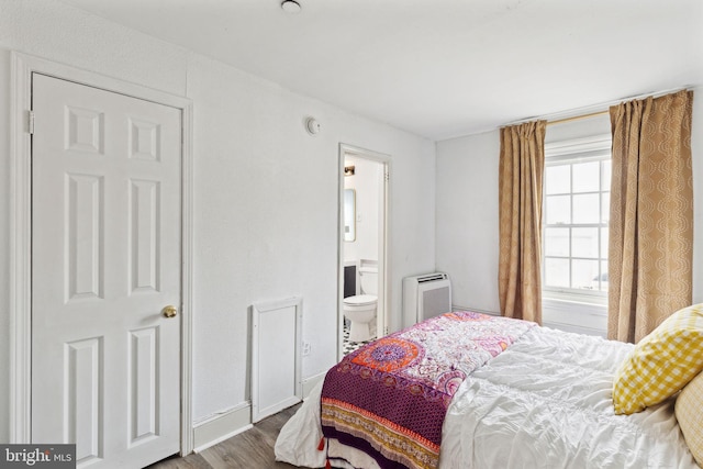 bedroom with wood-type flooring and connected bathroom