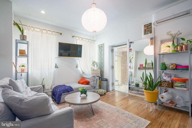 living room with an AC wall unit and hardwood / wood-style floors