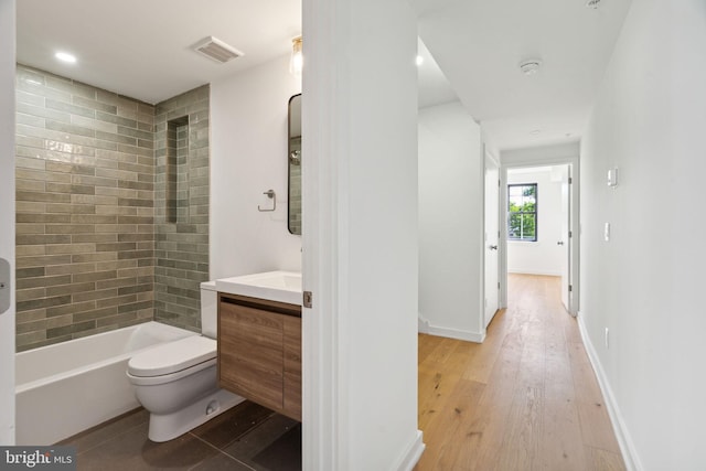 full bathroom featuring wood-type flooring, vanity, toilet, and tiled shower / bath