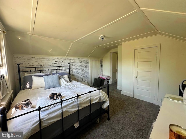 carpeted bedroom with vaulted ceiling and brick wall