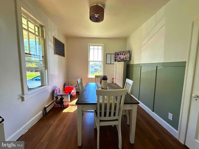 dining room with baseboard heating and dark hardwood / wood-style flooring