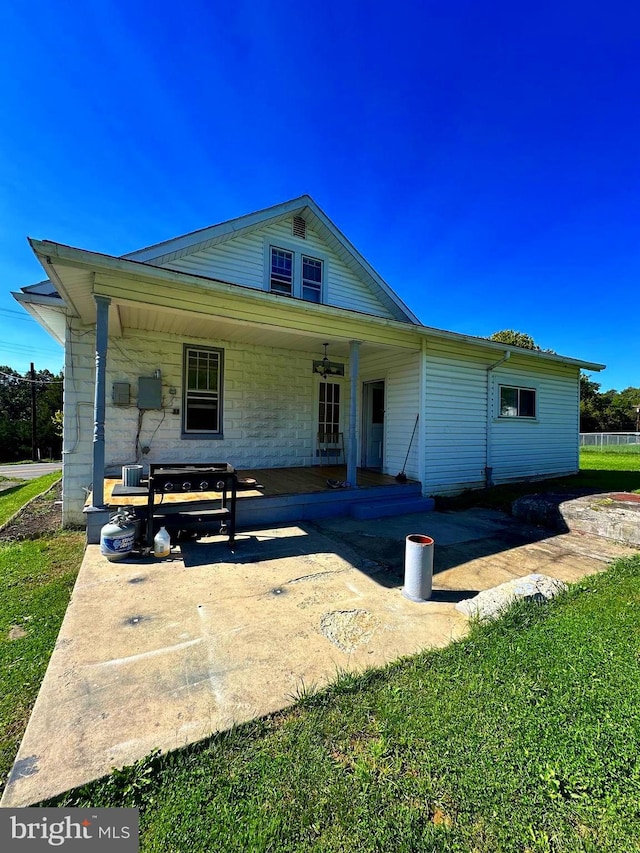 back of house featuring a porch and a yard