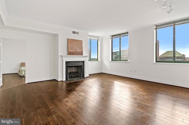 unfurnished living room featuring crown molding and dark wood-type flooring