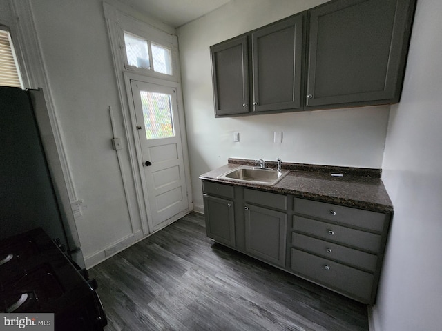 kitchen with fridge, gray cabinets, dark hardwood / wood-style floors, and sink