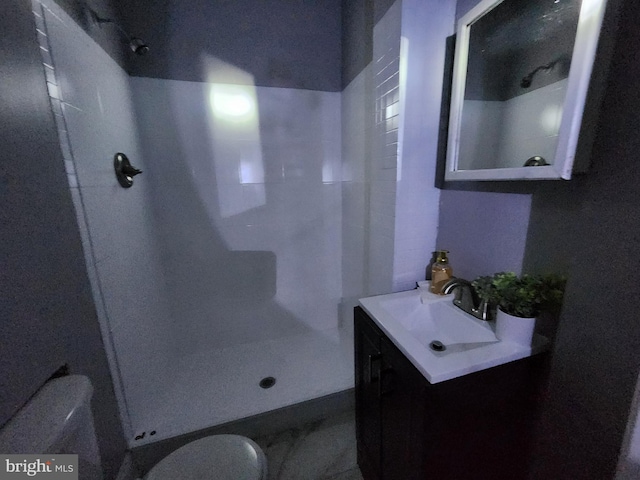 bathroom featuring vanity, a shower, and toilet