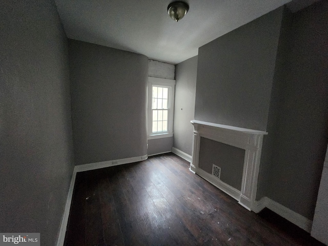 unfurnished living room with dark wood-type flooring