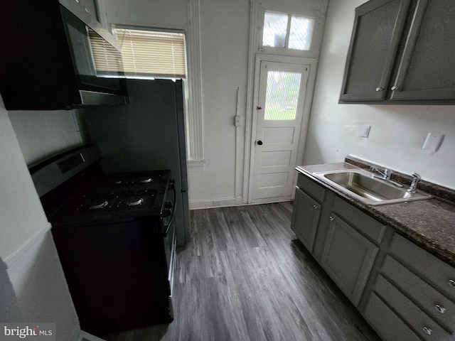 kitchen featuring black range, sink, dark hardwood / wood-style flooring, and gray cabinetry