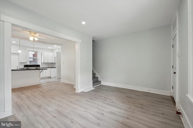 unfurnished living room with ceiling fan and light hardwood / wood-style flooring