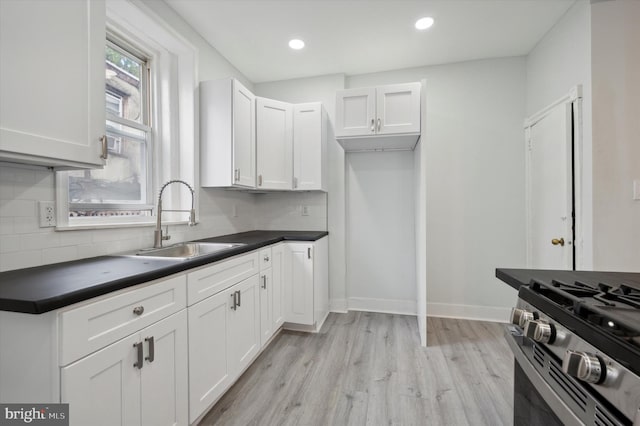 kitchen featuring light hardwood / wood-style flooring, white cabinets, backsplash, and sink