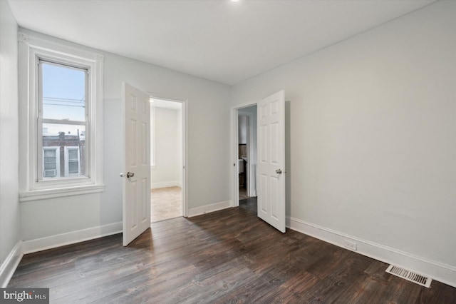 unfurnished bedroom featuring dark hardwood / wood-style flooring