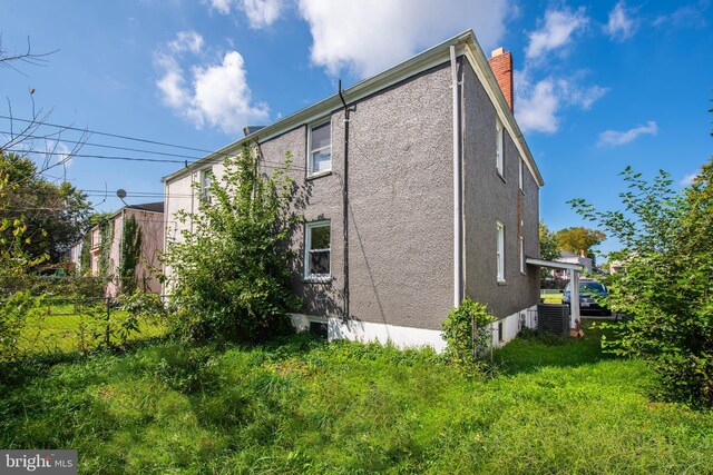 view of home's exterior featuring a yard and central AC