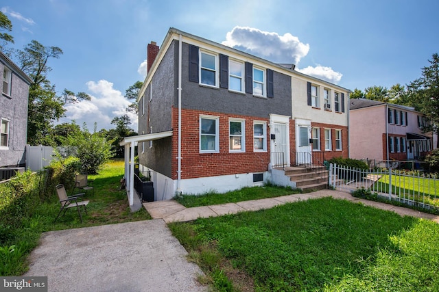 view of front of home with a front lawn and central air condition unit