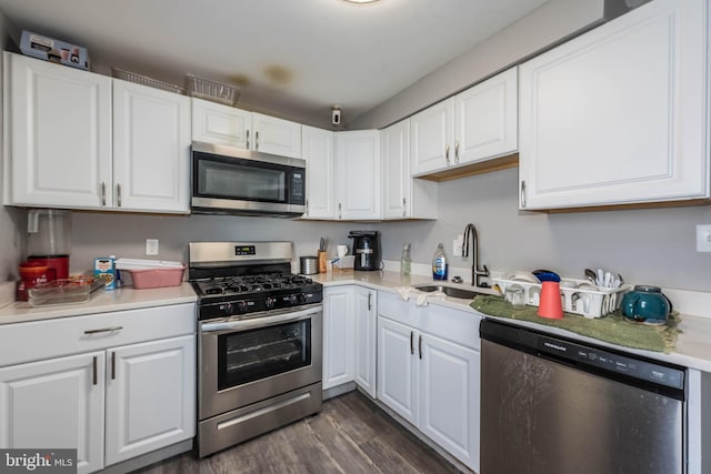 kitchen with stainless steel appliances, dark wood-type flooring, sink, and white cabinetry