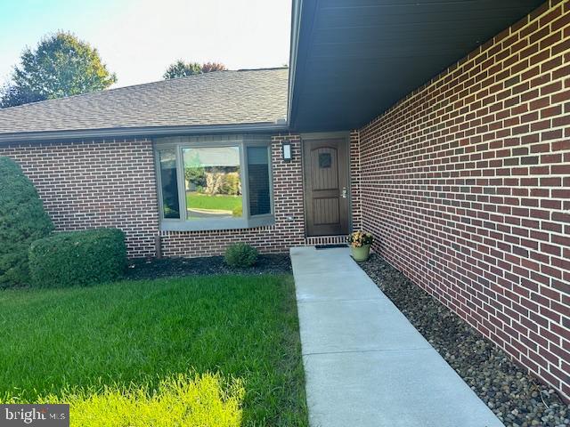 entrance to property featuring a lawn