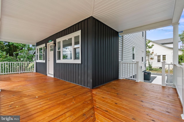 wooden deck with cooling unit and covered porch