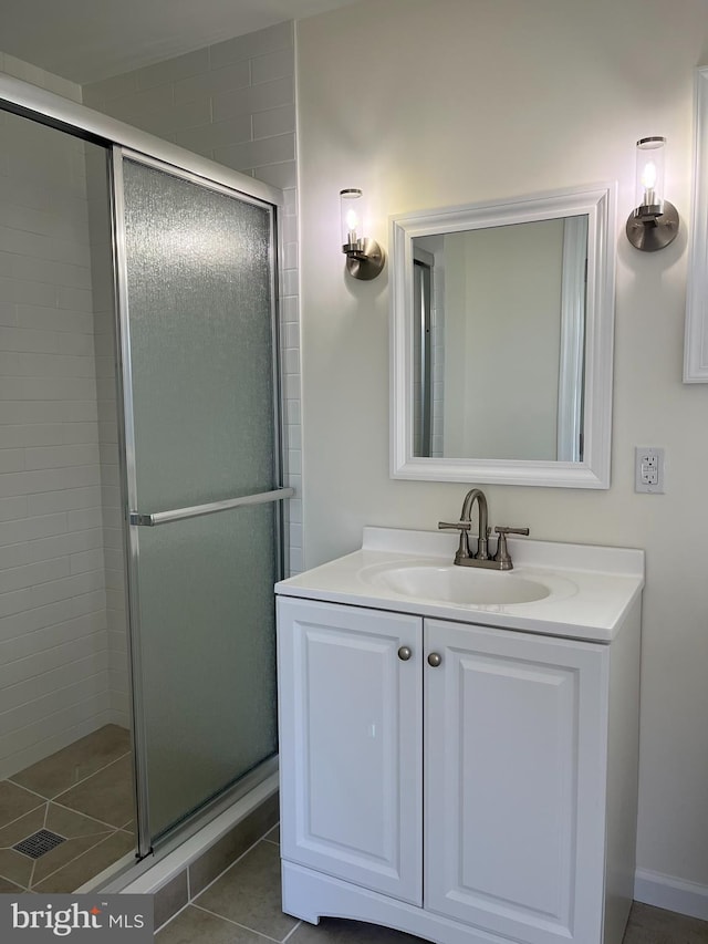 bathroom with tile patterned floors, a shower with shower door, and vanity