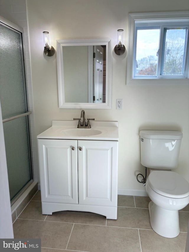 bathroom with vanity, tile patterned flooring, toilet, and an enclosed shower