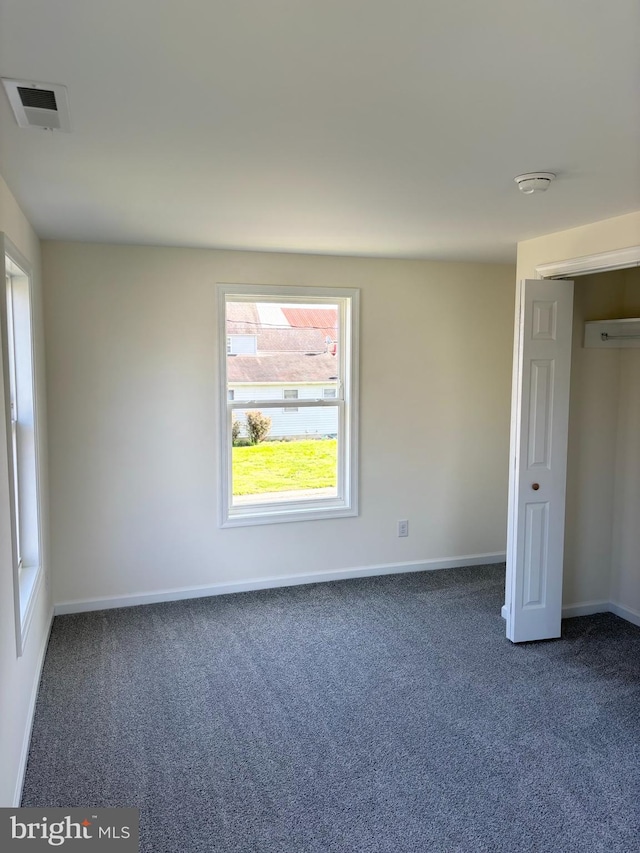 unfurnished bedroom with dark carpet