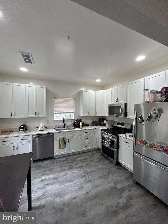 kitchen with white cabinets, appliances with stainless steel finishes, and sink