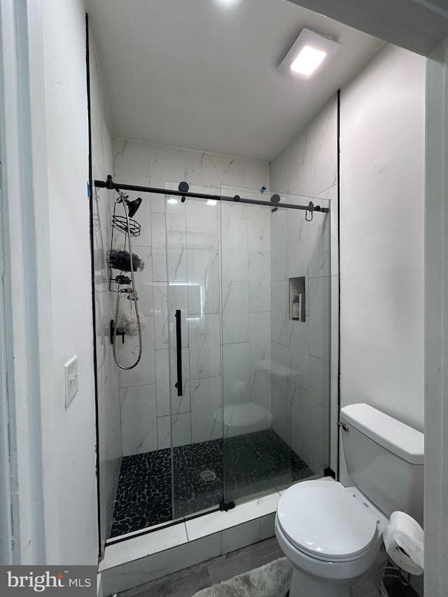 bathroom featuring walk in shower and toilet