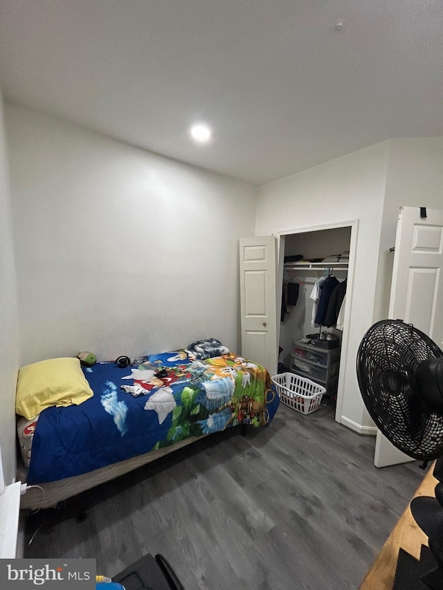 bedroom with baseboards, wood finished floors, and a closet