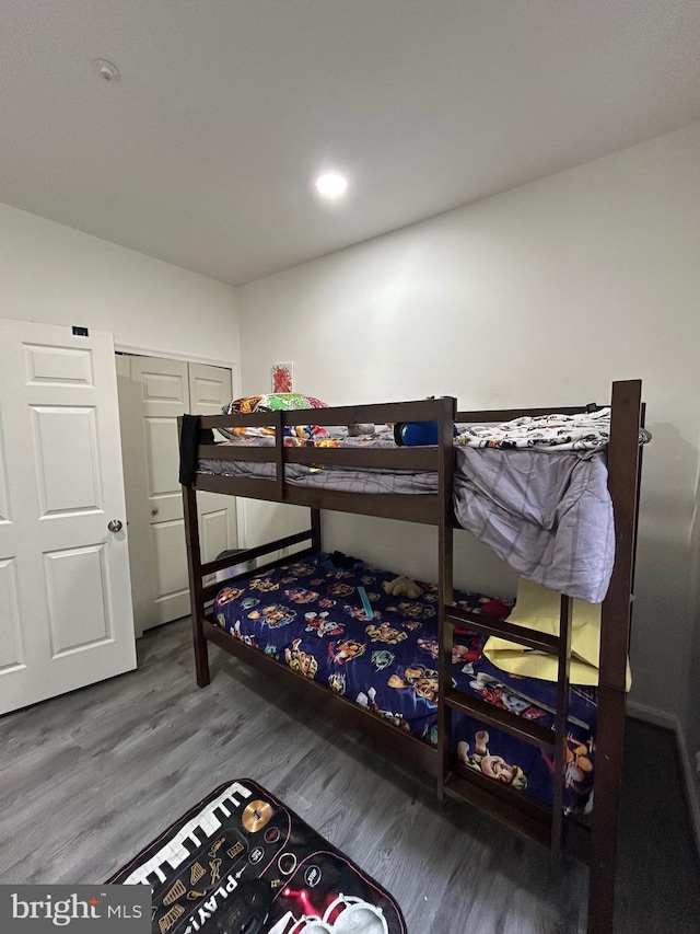 bedroom with recessed lighting, wood finished floors, and a closet